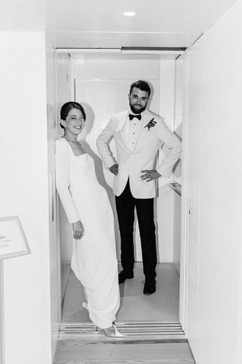 The bride and groom share a relaxed and intimate moment together just before entering the dining room, a calm pause ahead of the evening’s celebration