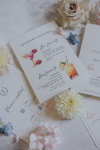 Wedding stationery and illustrated cocktail menus displayed with flowers during a destination wedding in Sintra, Portugal.