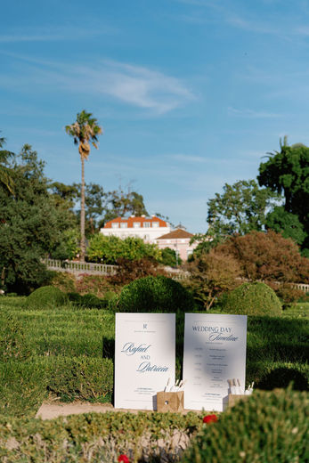 A welcome sign greets guests upon arrival, paired with delicate white parasols offered for their comfort during the ceremony, setting a considerate and elegant tone from the very first moment