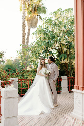 "Romantic shot of the groom watching the bride in a lush garden setting.