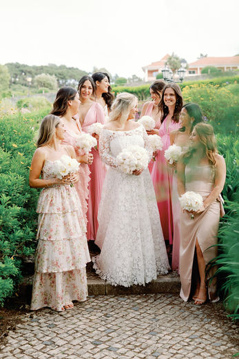 A relaxed, editorial-style photo of the bride surrounded by her bridal party, laughing and talking at Penha Longa Resort