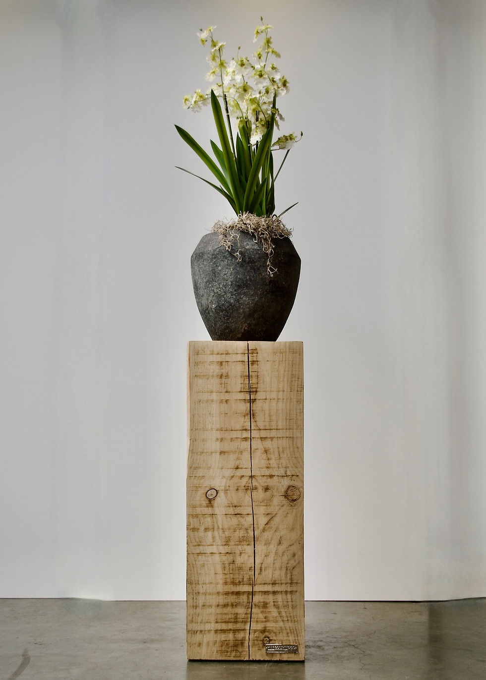Gedecoreerde Sydney Post meerpaal sokkel met een grote pot en orchidee erop.