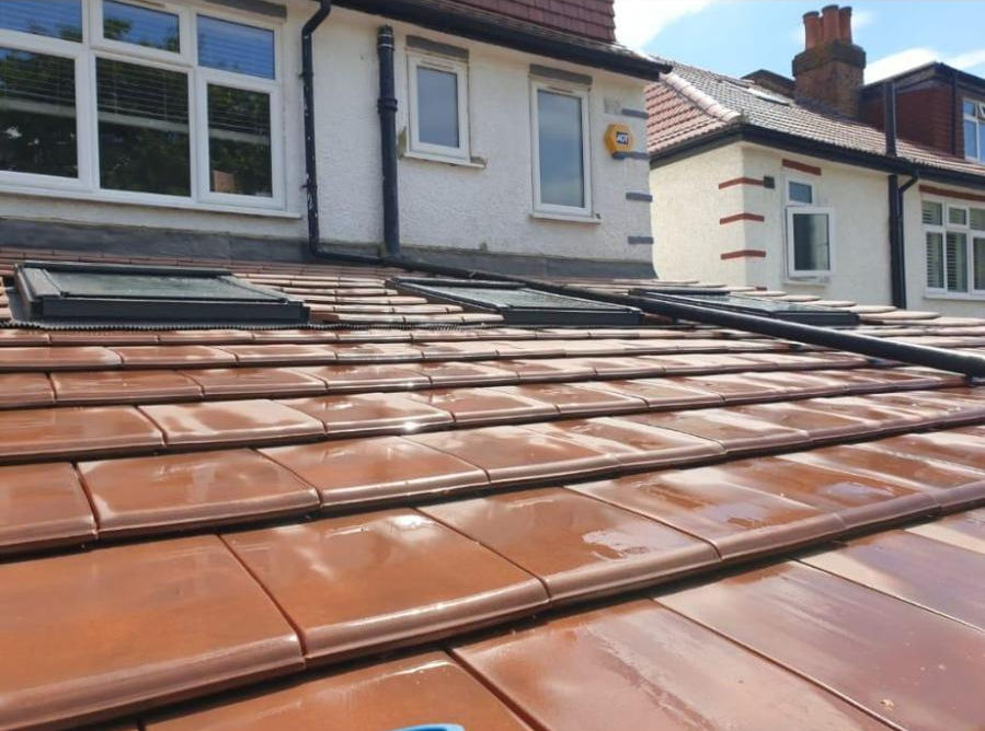 Newly laid terracotta roof tiles on a residential property with skylights