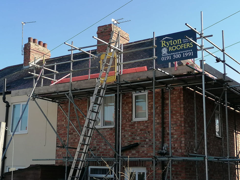 Scaffolding surrounds a brick house during roof repair by Ryton Roofers