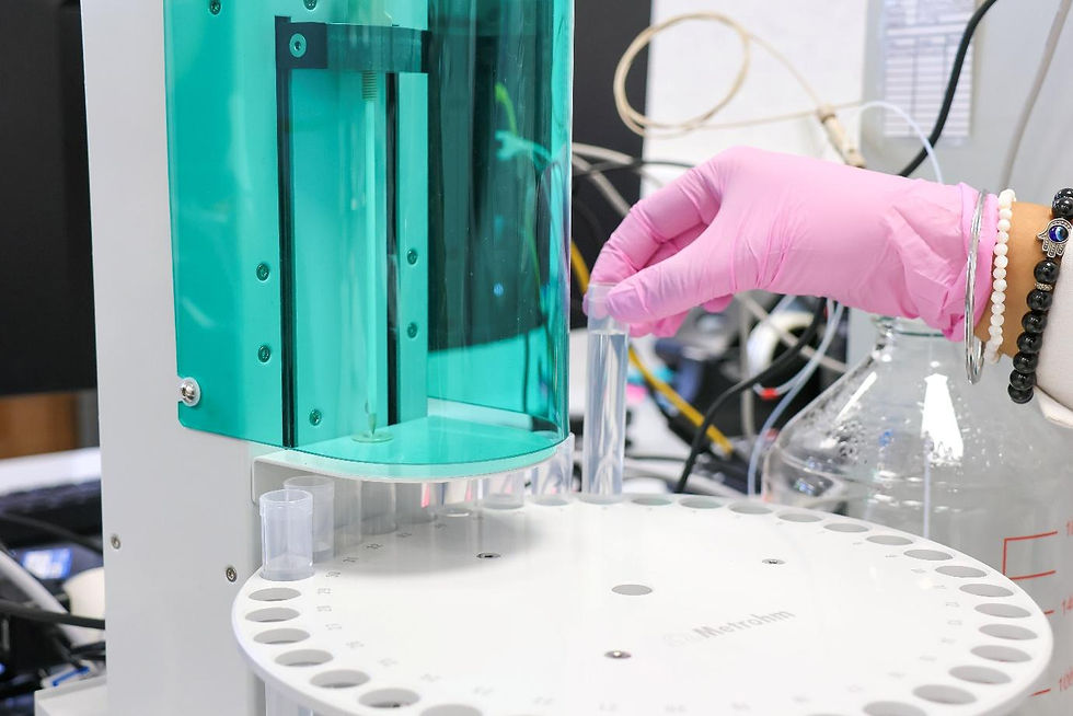 Gloved hand placing a sample vial into a Metrohm automated titrator