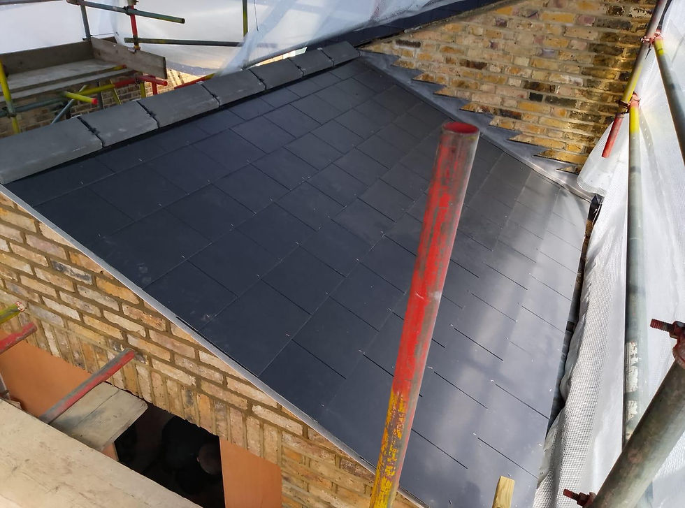 New dark slate roof being installed on a brick building with scaffolding