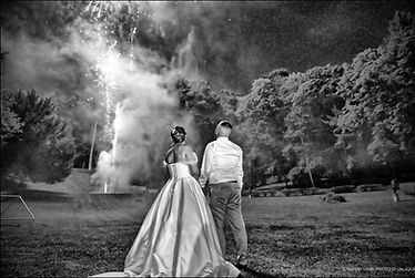 Couple de mariés regardant le feu d'artifices de leur mariage. Photo en noir et blanc par Christelle Levilly