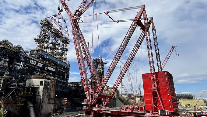 30 Second Takeaway Mammoet has successfully supported a major coke drum integrity upgrade at a large Canadian oil sands mining operation in Fort McMurray, Alberta, completing the replacement of eight coke drums ahead of schedule. Early involvement, detailed planning, and the strategic use of heavy lifting and transport solutions proved critical in reducing shutdown time and extending the life of the upgrader by an estimated 30 years. Coke Drum Replacement Scope Supporting a Critical Upgrader Process The oil sands upgrader uses thermal and chemical processes, including coking and hydrotreating, to convert bitumen into synthetic crude oil. During this refining process, coke drums collect petroleum coke separated from the feedstock, making them essential components within the facility. Each coke drum weighed approximately 270 tonnes and measured 7.9 metres in diameter and 29.8 metres in height. Positioning components of this size required one of the world’s largest cranes and a carefully engineered lifting strategy. Heavy Lift Engineering and Crane Selection Reach as the Deciding Factor Mammoet conducted extensive feasibility and crane selection studies for the project. Rather than lifting capacity alone, crane reach was identified as the critical factor, enabling the replacement work to proceed without interrupting other concurrent maintenance activities across the site. The team selected the PTC210DS ring crane , which allowed lifts to be performed from a greater distance. Because the crane was installed inside the coke pit, significant civil works were required, including the installation of approximately 200 piles to create a stable foundation for the crane. Transport and On-Site Execution SPMTs Enable Continuous Progress New coke drum components were delivered well in advance from Edmonton to Fort McMurray. Once on site, Mammoet used self-propelled modular transporters (SPMTs) to position the components efficiently. Two SPMT sets operating day and night enabled continuous progress, helping to accelerate turnaround execution. Mammoet also fabricated specialized rigging and adjusted crane configurations when one component was found to be heavier than initially estimated, ensuring the project remained on schedule despite changing conditions. About Mammoet Mammoet is a global leader in engineered heavy lifting and transport services, supporting the construction, maintenance, and decommissioning of large-scale infrastructure and industrial projects worldwide. With more than two centuries of combined experience, Mammoet specializes in moving and installing the largest and heaviest objects on earth. In Canada’s oil sands, Mammoet has been an active partner since 1967, providing heavy lift engineering, crane services, and transport solutions that help operators execute complex shutdowns, turnarounds, and capital projects safely and efficiently. Website: https://www.mammoet.com Frequently Asked Questions What was the scope of Mammoet’s work in Fort McMurray? Mammoet supported the replacement of eight coke drums at a large oil sands upgrader, including feasibility studies, crane selection, heavy lifting, transport using SPMTs, and on-site execution support. Why was early planning important for this project? Early planning allowed Mammoet to develop the optimal lifting and transport strategy, minimize shutdown duration, and coordinate work alongside other site maintenance activities. Which crane was used for the coke drum installation? The project utilized Mammoet’s PTC210DS ring crane, selected primarily for its reach, allowing lifts to be executed without disrupting other operations. How were the coke drums transported on site? The coke drums were moved on site using self-propelled modular transporters, with two SPMT sets operating continuously to maintain progress and support an accelerated turnaround schedule. What long-term benefit does the upgrade provide? The coke drum replacement is expected to extend the operational life of the upgrader by approximately 30 years.
