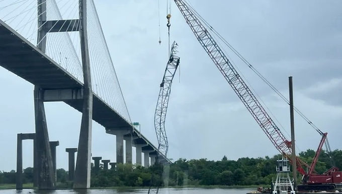 30-Second Takeaway A lattice crawler crane boom struck the underside of the Talmadge Memorial Bridge in Savannah on Friday while being transported on a barge along the Savannah River. The boom subsequently went over the rear of the crane and fell onto the barge deck and into the water. No injuries were reported. Georgia Department of Transportation temporarily closed the bridge for inspection before reopening it several hours later. Recovery operations removed the fallen boom later the same day. Incident Overview A lattice crawler crane  mounted on a barge  was involved in a bridge-strike incident on Friday   August 1st  while transiting beneath the Talmadge Memorial Bridge  in Savannah, Georgia . As the barge attempted to pass under the bridge, the crane’s boom struck the underside of the main span . Following the impact, the boom went over the rear of the crane , crashing onto the barge deck and into the river. What Is Known Location:  Savannah River, Savannah, Georgia Bridge involved:  Talmadge Memorial Bridge (US 17 / SR 404 Spur) Crane type:  Lattice crawler crane mounted on a barge Tow vessel:   Lorna Myrick , owned by Myrick Marine Injuries:  None reported The incident was captured on video  by personnel aboard another barge and crane travelling in the same direction. Official Response The Georgia Department of Transportation (GDOT)  issued a statement following the incident, confirming the temporary closure of the bridge: “The US 17/SR 404 Spur Bridge in Savannah will be closed beginning this afternoon so that the agency can conduct an inspection of the bridge, following a bridge strike incident in which a crane struck the underside of the main span of the bridge during a crane transit on the Savannah River.” GDOT stated the bridge would remain closed for an indeterminate period out of an abundance of caution  while inspections were completed. The bridge was reopened approximately four hours later  after inspections confirmed it was safe for public use. Recovery Operations Following the strike: Another barge-mounted crane  was mobilized to assist The fallen boom was removed from the deck and water Recovery photos were taken once the operation was complete No environmental or structural damage beyond the crane itself has been confirmed at this stage. Investigation Status At the time of publication: No official findings have been released regarding clearance calculations or transit planning Authorities have not confirmed whether tide level, boom configuration, or bridge clearance contributed to the strike Further details may be released following review by marine and transport authorities. Why Incidents Like This Can Occur Bridge-strike incidents during crane barge movements can occur due to: Insufficient air-draft clearance planning Changes in tide or river level Boom not fully secured or lowered for transit Limited visual reference when approaching bridge spans Marine crane transport requires precise coordination between crane configuration, vessel draft, and bridge clearance. Industry Reminder Crane barge movements combine marine navigation risks with heavy-lift hazards. Bridge clearance errors can escalate rapidly, even at low speeds. The absence of injuries in this incident was fortunate and underscores the importance of conservative clearance planning and disciplined transit procedures . Editorial Note Crane Hub Global reports on crane and heavy-lift incidents to support industry awareness and prevention. This article reflects confirmed information available at the time of publication and will be updated if official findings are released. How Incidents Like This Can Be Prevented Verified Air-Draft Calculations Transit plans should include verified maximum crane height , factoring in boom position, vessel motion, and water level. Tide and Water-Level Monitoring Bridge clearance should be reassessed immediately prior to transit based on actual tide and river conditions , not scheduled estimates. Transit-Specific Crane Configuration Booms should be lowered, secured, and locked  in approved transport positions before passing under fixed structures. Pilotage and Clearance Spotters Dedicated clearance spotters or pilots can help confirm safe passage under bridges during marine transits. Stop-Transit Authority Tug operators and supervisors must retain authority to abort transits  if clearance margins appear insufficient.