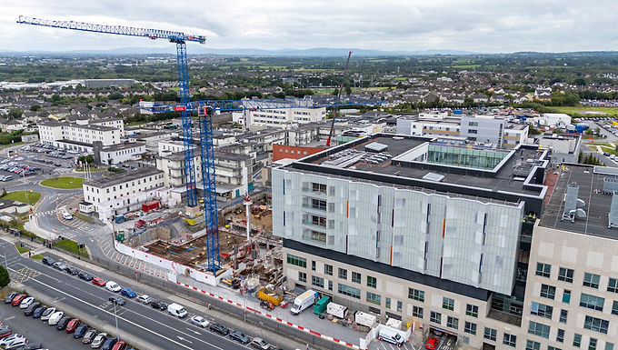 30-Second Takeaway Irish Crane and Lifting has deployed two Raimondi flat-top tower cranes , an MRT234 and MRT294, on the University Hospital Limerick expansion project. Installed within a live hospital environment, the cranes provide the reach and lifting capacity required for a complex, multi-phase redevelopment programme designed to increase healthcare capacity across the region. Raimondi MRT234 and MRT294 Tower Cranes Irish Crane and Lifting has strengthened its support for critical healthcare infrastructure by installing two Raimondi tower cranes at the University Hospital Limerick campus. The company, Raimondi’s official agent in Ireland, erected one MRT234 and one MRT294 as part of a wider three-phase redevelopment programme aimed at expanding and modernising hospital facilities to meet growing regional demand. The expansion project is designed to significantly enhance healthcare capacity while maintaining full operational continuity at the live hospital site. Supporting a Multi-Phase Healthcare Development The MRT234 previously operated during Phase One of the redevelopment, which delivered a four-storey building providing 96 additional beds. As construction progressed into Phase Two, the crane was repositioned onsite during the third quarter of 2025 to support the next stage of works. The MRT234 now operates: Freestanding at 41 metres With a 55 metre jib Delivering a 4.2 tonne tip load Working alongside it, the newly erected MRT294 reaches: 60.5 metres in height A 70 metre jib A 3.5 tonne tip load Both flat-top cranes are expected to remain in their current configurations for the duration of the project. Tower Crane Operations in a Live Hospital Environment Hospital Expansion Tower Crane Deployment Deploying cranes adjacent to an operational hospital campus presents unique logistical and safety challenges. According to Irish Crane and Lifting, the pairing of the two Raimondi flat-top cranes provides the reach, flexibility and lifting precision required for a constrained construction site bordered by active healthcare facilities and public infrastructure. Installation required detailed pre-planning due to: Restricted working space Ongoing hospital operations The need to keep a nearby public road open Tight coordination with project stakeholders A 450 tonne mobile crane was used to complete the erection process safely and efficiently. The selection of flat-top cranes supports improved oversailing management and simplified coordination in confined environments, reducing interference with surrounding structures and public areas. Long-Term Commitment to Infrastructure Projects The cranes are expected to remain onsite for approximately 18 months as the redevelopment progresses through its next phases. Irish Crane and Lifting operates more than 60 Raimondi tower cranes across Ireland, supporting large-scale residential, commercial and infrastructure projects nationwide. The University Hospital Limerick expansion underscores the growing demand for modern healthcare infrastructure and highlights the crane sector’s role in enabling critical public works. By delivering precision lifting solutions in sensitive and space-constrained environments, Irish Crane and Lifting continues to reinforce its position within Ireland’s major infrastructure development landscape. About Irish Crane and Lifting Irish Crane and Lifting is a leading tower crane rental company in Ireland and the official Raimondi agent for the country. The company operates a fleet of more than 60 Raimondi tower cranes and supports large-scale residential, commercial and infrastructure projects nationwide. About Raimondi Cranes Raimondi Cranes is an international tower crane manufacturer specialising in flat-top, luffing jib and hammerhead crane models used across global construction markets. Website: https://www.raimondicranes.com Frequently Asked Questions Which cranes were installed at University Hospital Limerick? Irish Crane and Lifting installed a Raimondi MRT234 and a Raimondi MRT294 flat-top tower crane. What is the height and jib length of the MRT294? The MRT294 operates at 60.5 metres in height with a 70 metre jib. Why were flat-top cranes selected? Flat-top cranes provide flexibility, reduced oversailing complications and efficient coordination in space-constrained sites such as operational hospital campuses. How long will the cranes remain onsite? The cranes are expected to remain on the project for approximately 18 months. How large is Irish Crane and Lifting’s fleet? The company operates more than 60 Raimondi tower cranes across Ireland.