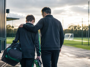 Academy Release Decisions: a father supports his young footballer walking away from the training ground after a difficult season decision.