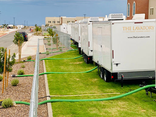 Multiple restroom trailers parked in a line under the open sky.