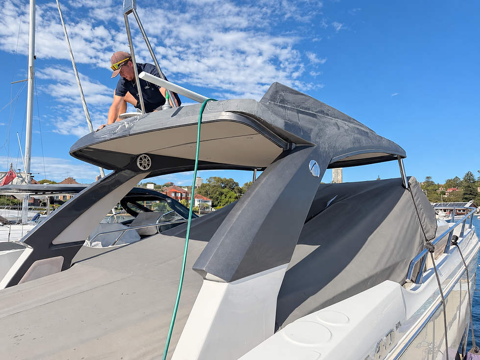 Installer preparing Absolute 40 Lucia’s hardtop roof for a new Satin Dark Grey vinyl wrap