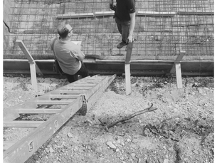 RIBA architect Simon Mack and site worker inspecting reinforced retaining wall with steel mesh and timber formwork during new build construction in Oxfordshire — Simon Mack Architecture