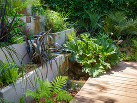 Massif végétal surélevé conçu dans un jardin paysager à Aix-en-Provence, composé de plantes vivaces, arbustes décoratifs, feuillages contrastés et paillage naturel. Aménagement esthétique, structuré et facile d’entretien.