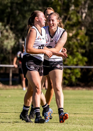 Two team mates celebrating kicking a goal