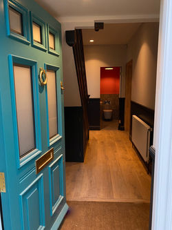A view of the front door and hallway with dark dado rail