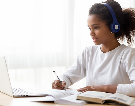 African American teen girl wearing headphones learning language online, using laptop, look