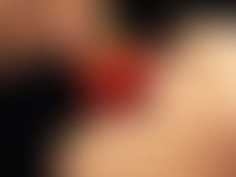 A woman's lips delicately embrace a ripe strawberry, highlighting the vibrant red hue against her smooth complexion.