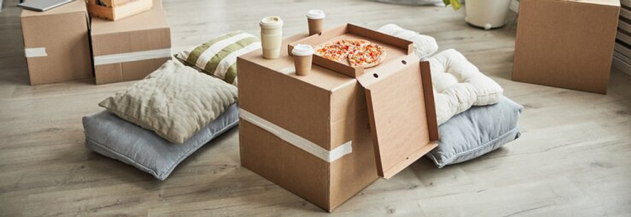 background-image-of-pizza-on-cardboard-box-as-makeshift-table-in-empty-room-while-family-m