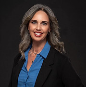 The mother of the two website authors, she had gray midlength hair, olive skin and large bright smile. She is wearing business professional clothes