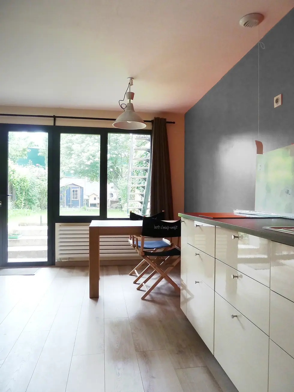 Cuisine équipée et espace dînatoire d'un studio contemporain ouvert sur le jardin à Arcueil.