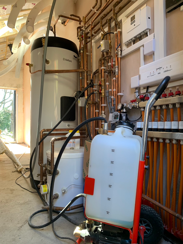 Vaillant aroTHERM plus air source heat pump installation plant room with unvented hot water cylinder, buffer and wiring centre. 