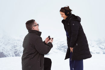 a man proposing on a snowy white mountaintop