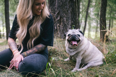 a young woman looks down at her aging pet with love