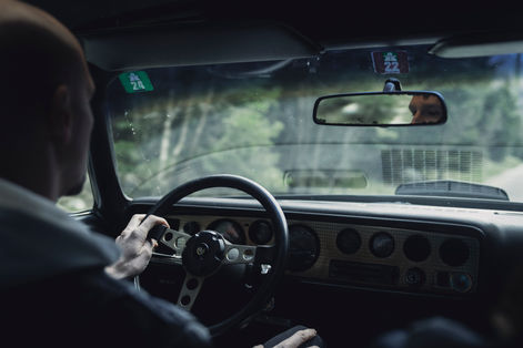 A man driving an old car