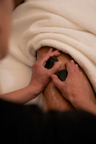 A spa professional administering a Hot Rock Massage at Hotel Julen