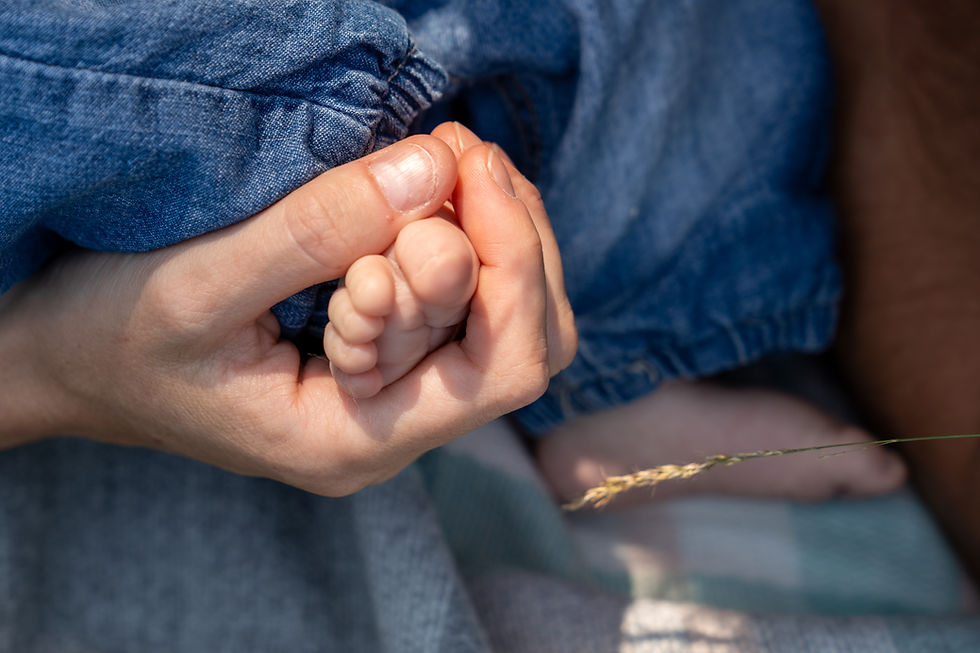 A parent holds their tiny baby's foot