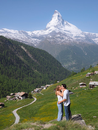a couple kissing sweetly in the bright, springtime mountainside of Zermatt