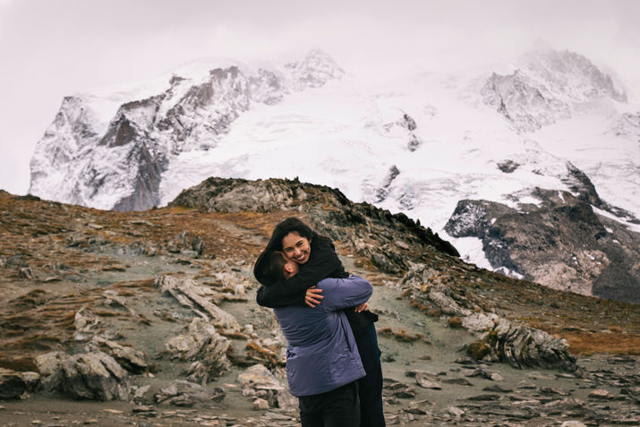 A man lifts his lady up for a twirl on a mountain lookout spot in Switzerland