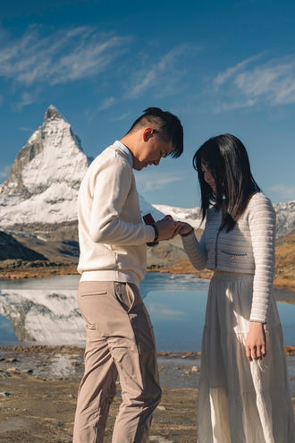 a pair of lovers gazing down at their engagement ring