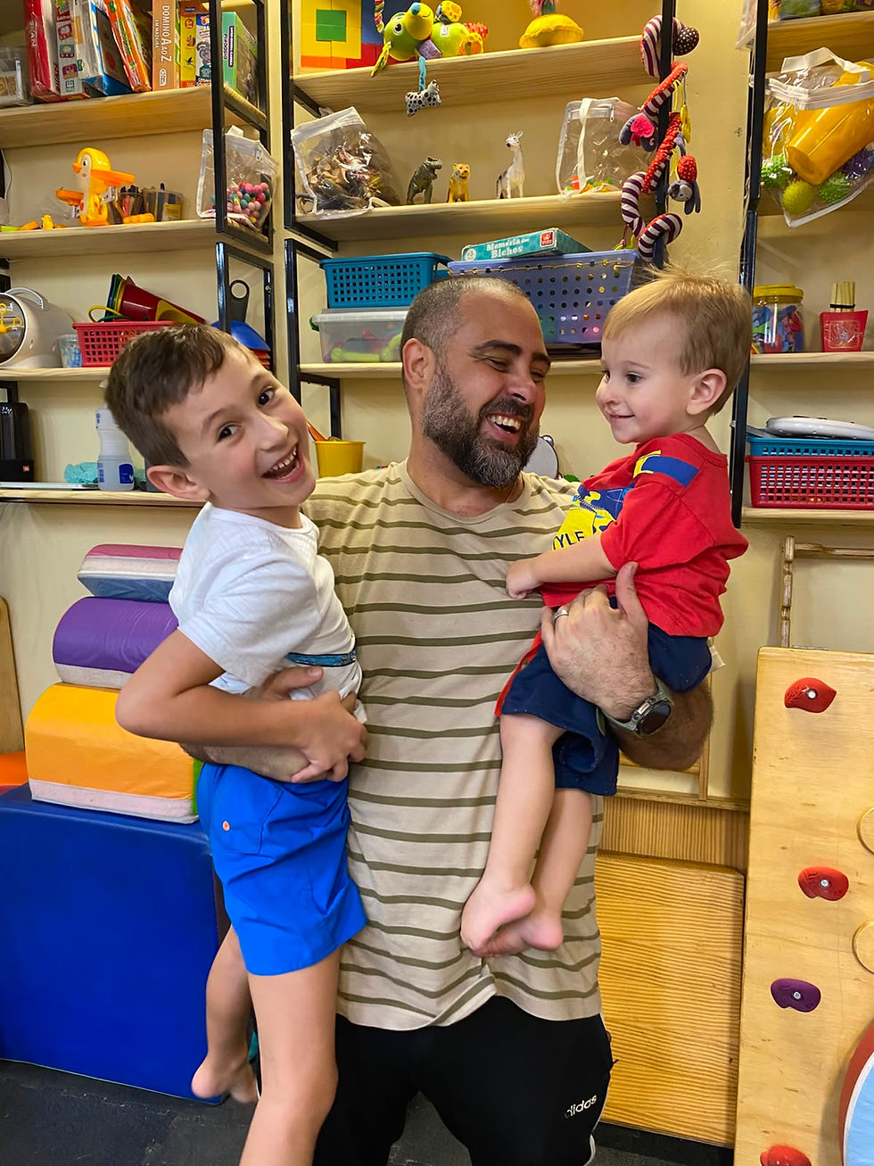 Eduardo Oliveira com duas crianças durante atendimento na PlayMovKids