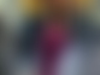 Nelly F. Fitness personal trainer performing a leaning single-arm cable lateral raise exercise to target medial delts and sculpt shoulders in the gym.