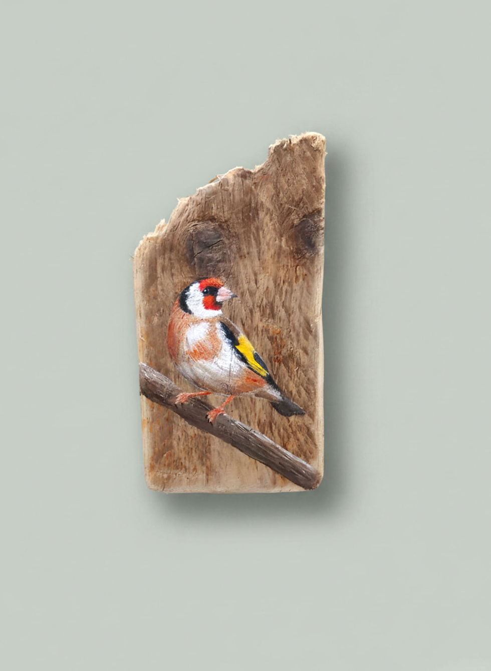 goldfinsh painting on driftwood