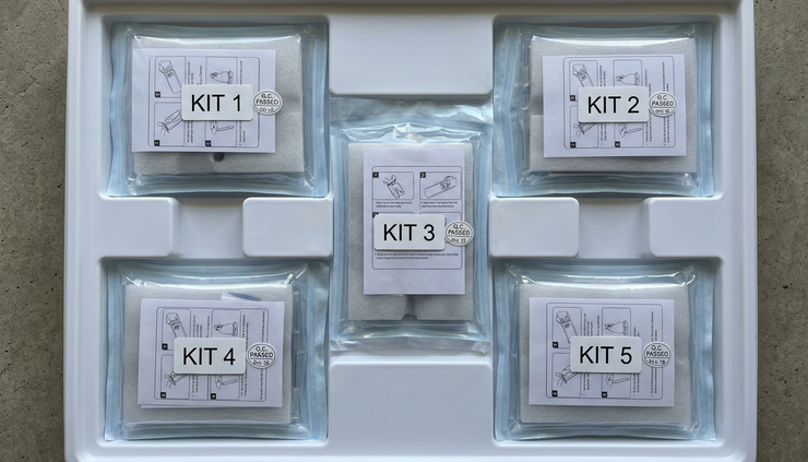 Overhead view of unbranded medical device kits arranged in a clean shipping tray.