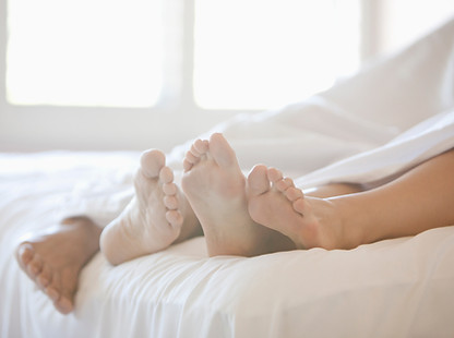 Paar Füße im Bett
