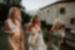 bruid met haar zus en moeder lopen omhoog voor groepsfoto tijdens bruiloft in Italiƫ