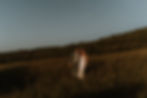 bruid en bruidegom tijdens golden hour op een berg in Umbriƫ lopend naar de camera