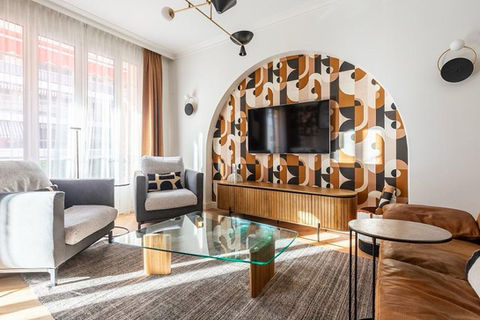 Salon rénové avec fauteuils modernes, télé murale et décor graphique boulevard Gambetta à Nice