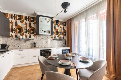 Cuisine blanche ouverte avec coin repas et baie vitrée dans appartement boulevard Gambetta