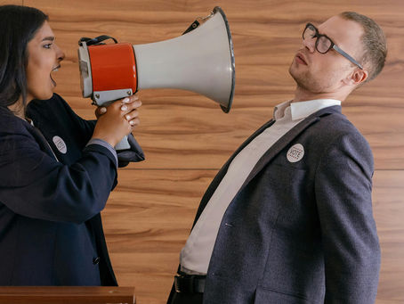 A man being yelled at through a megaphone.