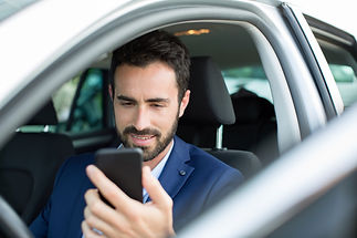 young-businessman-reading-smartphone-texts-in-car-2023-11-27-05-29-53-utc.jpg