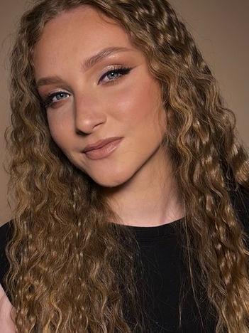 Soft, natural beauty with subtle blush and groomed brows.