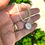 Thumbnail: hand holding beaded necklace with round silver moon charm