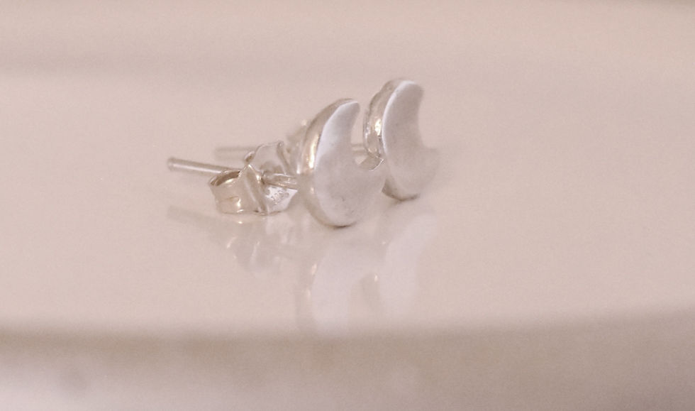Thumbnail: pair of silver crescent moon stud earrings on shiny surface side view