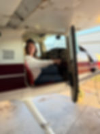 Female pilot or passenger posing in the cockpit of an aircraft.